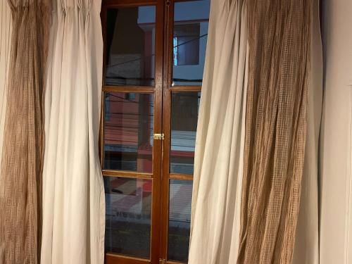 奇瓦伊SierraAlta的客房内的木制窗户配有白色窗帘