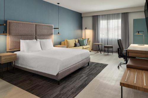 阿拉胡埃拉阿拉胡埃拉圣荷西机场万怡酒店的配有一张床和一张书桌的酒店客房