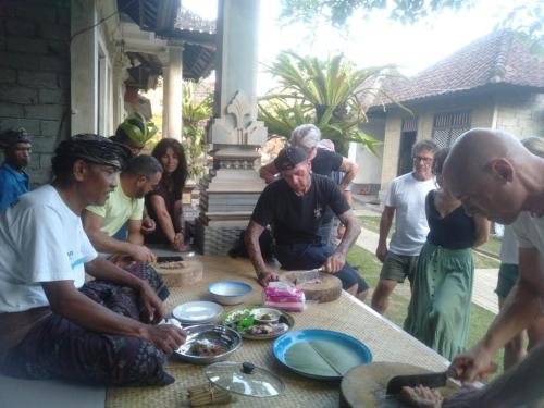 PetangPinge Traditional Village的一群人站在桌子旁吃着食物