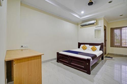 柴瑞海滩SPOT ON 81226 Cherai Rest Home的一间卧室配有一张床和一张书桌