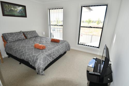 达博Ascot Gardens Serviced Apartments的一间卧室配有带橙色枕头和行李箱的床