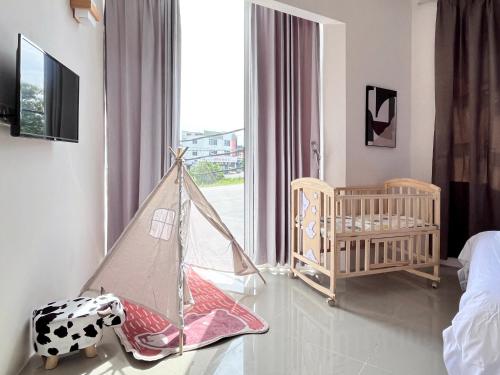 亚娄Vilana Hotel的一间婴儿房,配有婴儿床,一间房间设有窗户