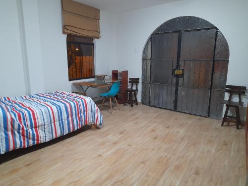 利马Terraza más habitaciones en La Molina的一间卧室配有一张床,拱门配有桌子