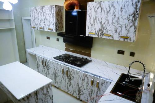 IkuataLuxury Charming 5Bed Duplex With Starlink wifi - Lekki的厨房配有白色大理石台面和炉灶。