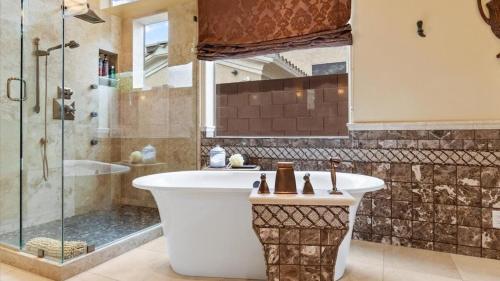 凤凰城Southwestern 4 Bdrm Retreat HTD Pool Game Room的设有带浴缸和淋浴的浴室。