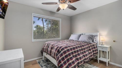 凤凰城North Phoenix 4 Bdrm Vacation Home wPool Games的一间卧室配有一张带吊扇和窗户的床。
