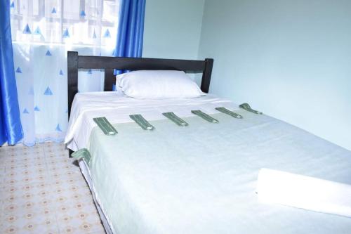 Ongata Rongai 3-bedroom, 2-bedroom, 1-bedroom serenity homes的一张带白色床单和枕头的床