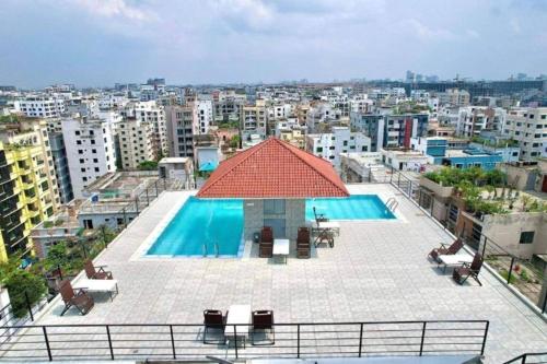 达卡Cozy Studio Apartment Basundhara的享有大楼顶部游泳池的景色
