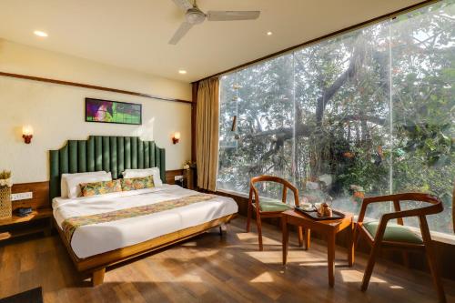 伯杰默里Pandav Inn的一间卧室设有一张床和一个大窗户