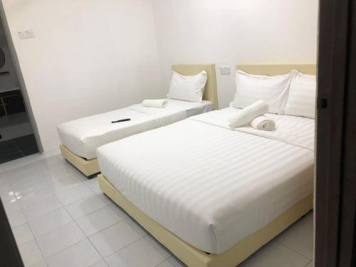 怡保SKYN SMART HOME的配有白色床单的酒店客房内的两张床