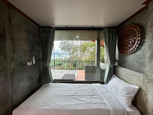 班柯木Rinna Resort的卧室在窗户前配有一张床