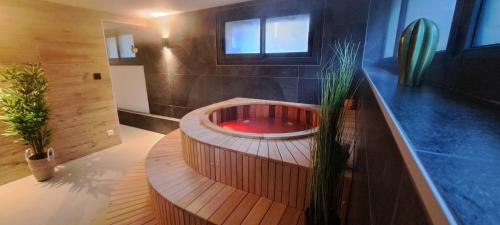 勒蒙多尔Alti'Pic Hôtel的浴室配有带红色水槽的木制浴缸