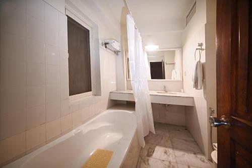 加德满都Nirvana Boutique Hotel的白色的浴室设有浴缸和水槽。