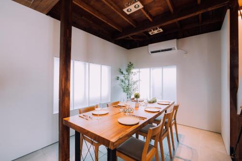 东京One Harajuku: Private Oasis的一间带木桌和椅子的用餐室
