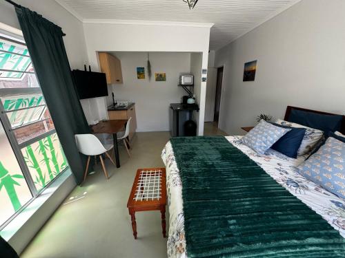 兰格班Tortoise Retreat的一间卧室配有一张床、一张书桌和一个窗户。