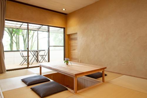 日出町kamenos Luxury Resort With Beautiful Scenery Hiji的客房设有木桌和大窗户。