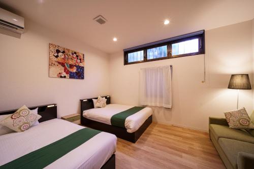 由布市Yufusouin - Vacation STAY 85705的客房设有两张床、一张沙发和一个窗口。