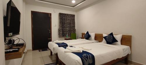 班加罗尔Hotel Amulya Regency的酒店客房设有两张床和电视。