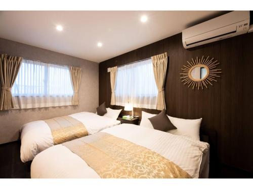 别府BEPPU NO YU TSUKI - Vacation STAY 87965的一间卧室设有两张床,墙上设有一面镜子