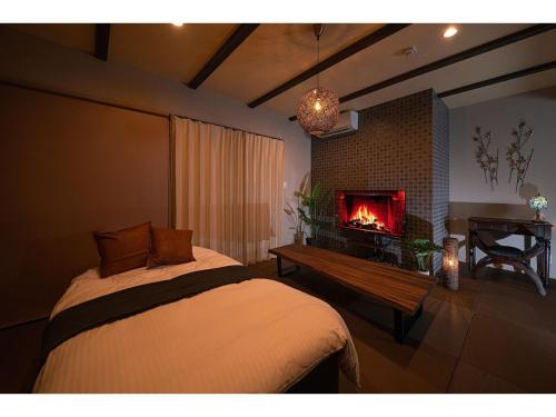 由布市YUHUROTEN YOJYOU NO BI - Vacation STAY 87032的一间卧室设有一张带壁炉的床。