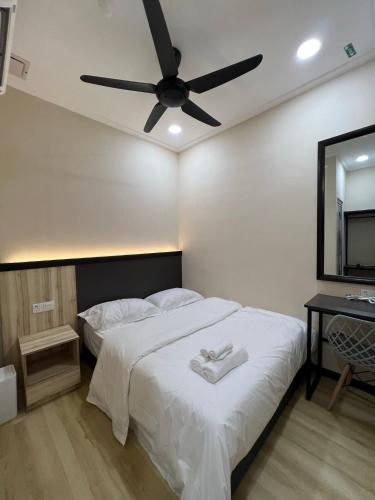哥打巴鲁Alia Express Dey Hotel的卧室配有白色的床和吊扇