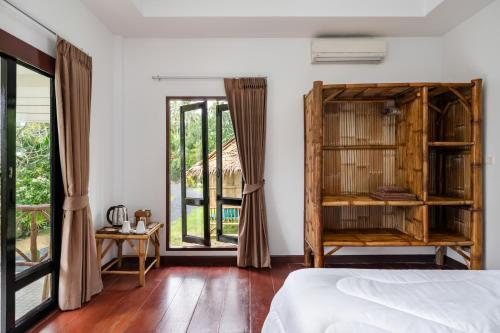 苏梅岛Tropical Heavens Garden Samui的一间卧室设有一张床和一个大窗户