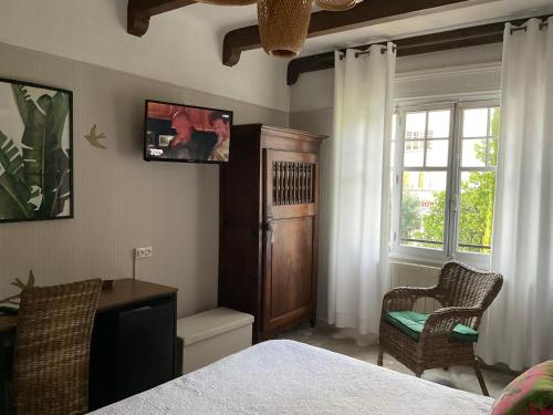 胡安莱潘玛尔乔莱娜酒店的一间卧室配有一张床、一张书桌和一个窗户。