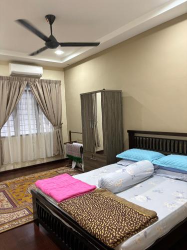 怡保Homestay Hajrah的一间卧室配有两张床和吊扇