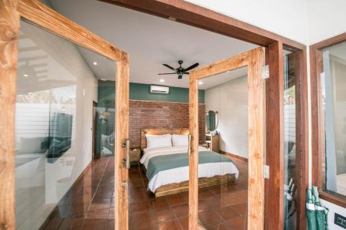 吉利特拉旺安Belukar Villas的一间卧室设有一张床和砖墙