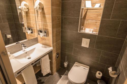 布达厄尔什Holiday Inn Budapest-Budaörs, an IHG Hotel的一间带水槽、卫生间和镜子的浴室