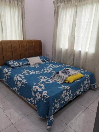 甲抛峇底Homestay Bajet Cikyah的一张带黄色枕头的蓝色棉被床