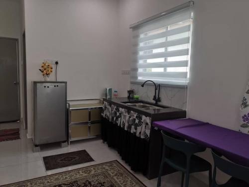 甲抛峇底Homestay Bajet Cikyah的厨房配有水槽和紫色台面