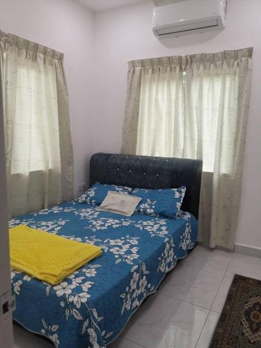 甲抛峇底Homestay Bajet Cikyah的一间卧室配有一张带蓝色毯子和窗帘的床