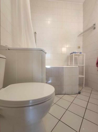 帕坦Cosy Room的白色的浴室设有卫生间和瓷砖地板。