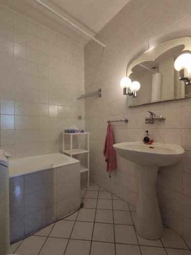 帕坦Cosy Room的浴室配有盥洗盆、镜子和浴缸