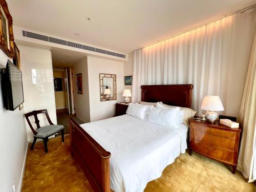 悉尼Sydney Cosmopolitan CBD Apartment的一间卧室配有一张床、一把椅子和电视