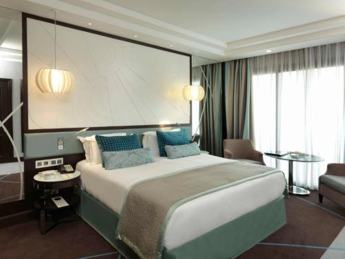 贝鲁特贝鲁特索菲特加布里埃尔酒店的酒店客房设有一张大床和一个大屏幕
