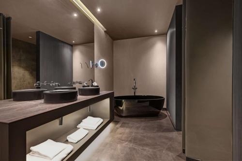 加亚新城Hilton Porto Gaia的浴室配有两个盥洗盆和浴缸。