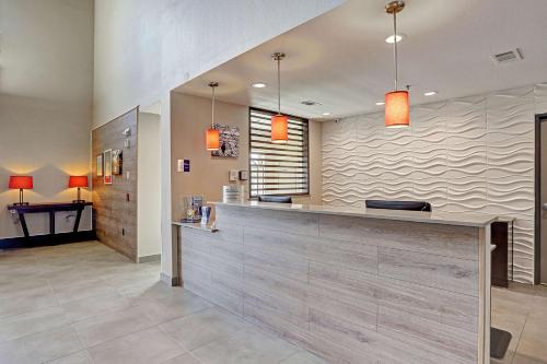 休斯顿Country Inn & Suites by Radisson Houston Westchase-Westheimer的大堂设有橙色灯光的前台