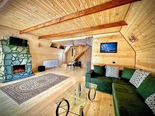 卡兹贝吉Hillside Kazbegi的客厅设有绿色沙发和壁炉