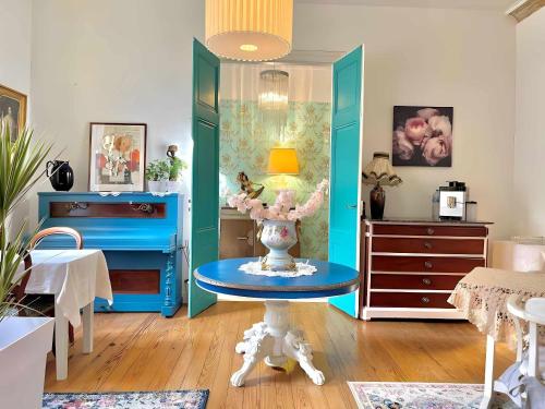 贝尔热拉克Maison B的一间设有蓝色家具和一张带花瓶的桌子的房间