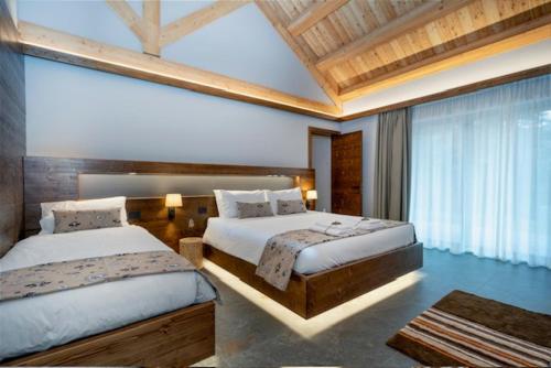 瓦尔布鲁纳Kile Alpine Resort的一间卧室设有两张床和大窗户
