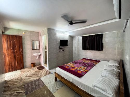 蓬蒂切里Royal Grand Residency的一间卧室配有一张床和一台电视。