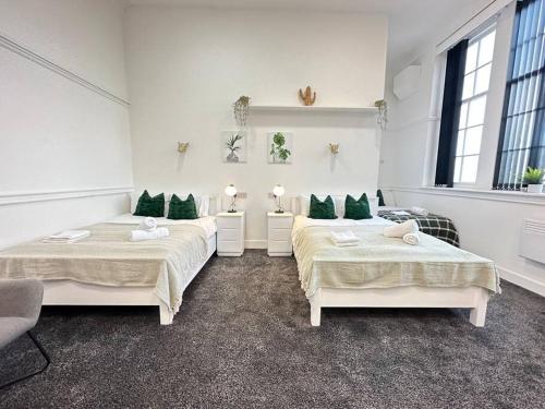 伯明翰Modern 3-Bed Haven in West Midlands!的客房 - 带两张带绿色枕头的床