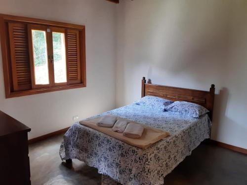 贡萨尔维斯Casa Recanto Lobo Guará的一间卧室配有一张床,上面有两条毛巾