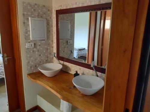 贡萨尔维斯Casa Recanto Lobo Guará的浴室设有2个水槽,位于带镜子的木柜台上