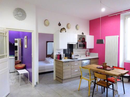 马赛Vieux Port Panier Jardin的厨房设有紫色墙壁和桌椅