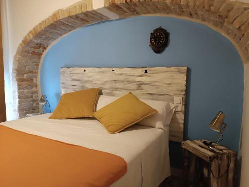 塔拉戈纳Petra apartments -Old City with terrace and barbecue-的一间卧室配有一张蓝色墙壁的床