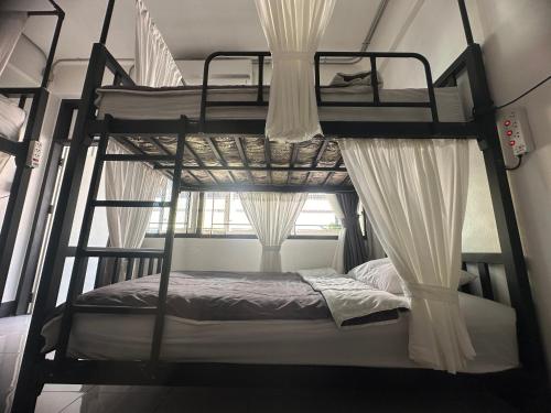 清莱Backpack Hostel的一间卧室设有两张双层床和一扇窗户。