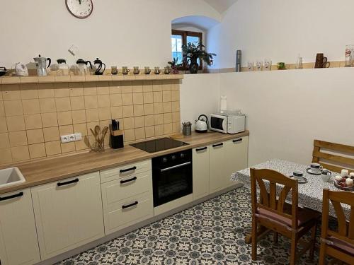 Malá MoravaUsedlost Pod lipou的厨房配有桌子和炉灶。 顶部烤箱